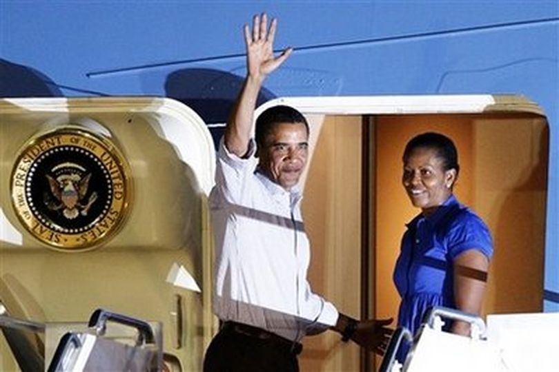 President Barack Obama and first lady Michelle Obama wave goodbye as they enter Air Force One at Hickam Air Force base in Honolulu, Sunday, Jan. 3, 2010.
(AP Photo/Chris Carlson) (Chris Carlson / Associated Press)