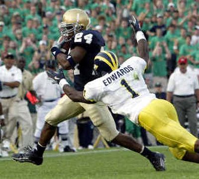 
Notre Dame's Dwight Ellick intercepts a pass in front of Michigan's Braylon Edwards.
 (Associated Press / The Spokesman-Review)