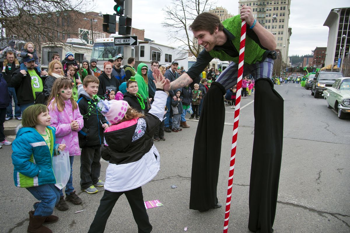 Gary Stone of Spokane Aerial Performance Arts greets young fans along Stevens Street during the St. Patrick’s Day Parade. (Dan Pelle)