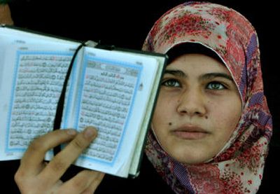 
A Palestinian woman holds a copy of the Quran during a rally Friday supporting the Hamas government in Gaza City. 
 (Associated Press / The Spokesman-Review)