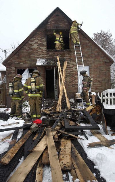 
Firefighters work Friday on the second floor of the house at 104 W. Park Place. The blaze killed Rick Starr, a retired sheriff's sergeant.
 (Dan Pelle / The Spokesman-Review)