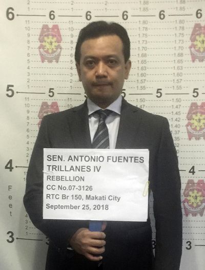 Philippine opposition Sen. Antonio Trillanes IV stands for his mugshot inside a police station in Makati, metropolitan Manila after the Makati Regional Trial Court Branch 150 issued an order for his arrest Tuesday, Sept. 25, 2018. (PHILIPPINE NATIONAL POLICE MAKATI / Associated Press)