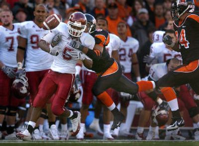 
Oregon State defensive back Al Afalava punches the ball out of the arms of Washington State University receiver Michael Bumpus after his second-half reception and long run on Saturday. 
 (Christopher Anderson/ / The Spokesman-Review)