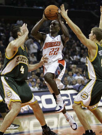 
Charlotte Bobcats' Brevin Knight (22) drives between a pair of Sonics.
 (Associated Press / The Spokesman-Review)