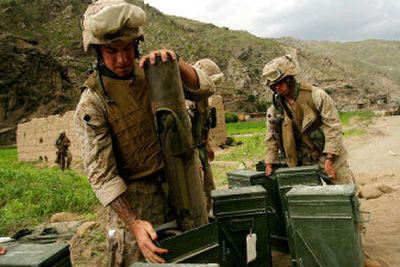 
U.S. Marines load mortar shell into containers as they set up defensive positions in Kandagal village in eastern Afghanistan on Thursday. Forces Saturday trekked from the base in Kandagal into remote Afghan mountains to retake a valley controlled by militants suspected of ambushing a team of U.S. commandos and shooting down a special forces helicopter.
 (Associated Press / The Spokesman-Review)