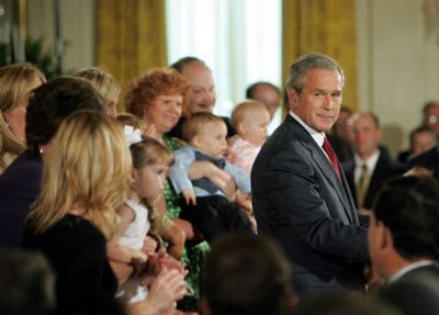 
Family members who have adopted children born from implanted embryos applaud President Bush on Wednesday as he explains his veto of a bill on embryonic stem cell research funding. 
 (Associated Press / The Spokesman-Review)