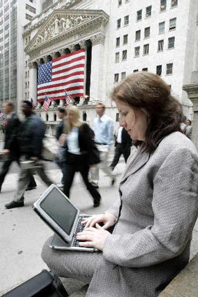 
Donna Childs, president and CEO of Childs Capital, works on her tablet PC near the New York Stock Exchange. 
 (Associated Press / The Spokesman-Review)