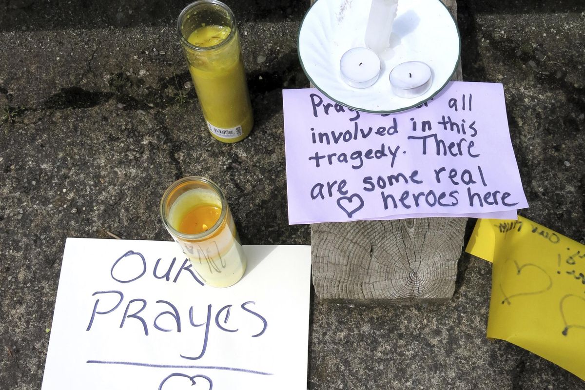 Well-wishing messages and candles for an injured employee are shown outside a grocery store in Estacada, Ore., Monday, May 15, 2017. Police say a man carrying what appeared to be a human head stabbed an employee at the grocery store. (Gillian Flaccus / Associated Press)