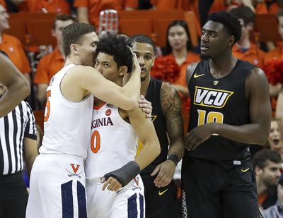 Virginia guards Kyle Guy (5) and Kihei Clark (0) celebrate a play against VCU on Sunday. Virginia won 57-49. (Andrew Shurtleff / Associated Press)