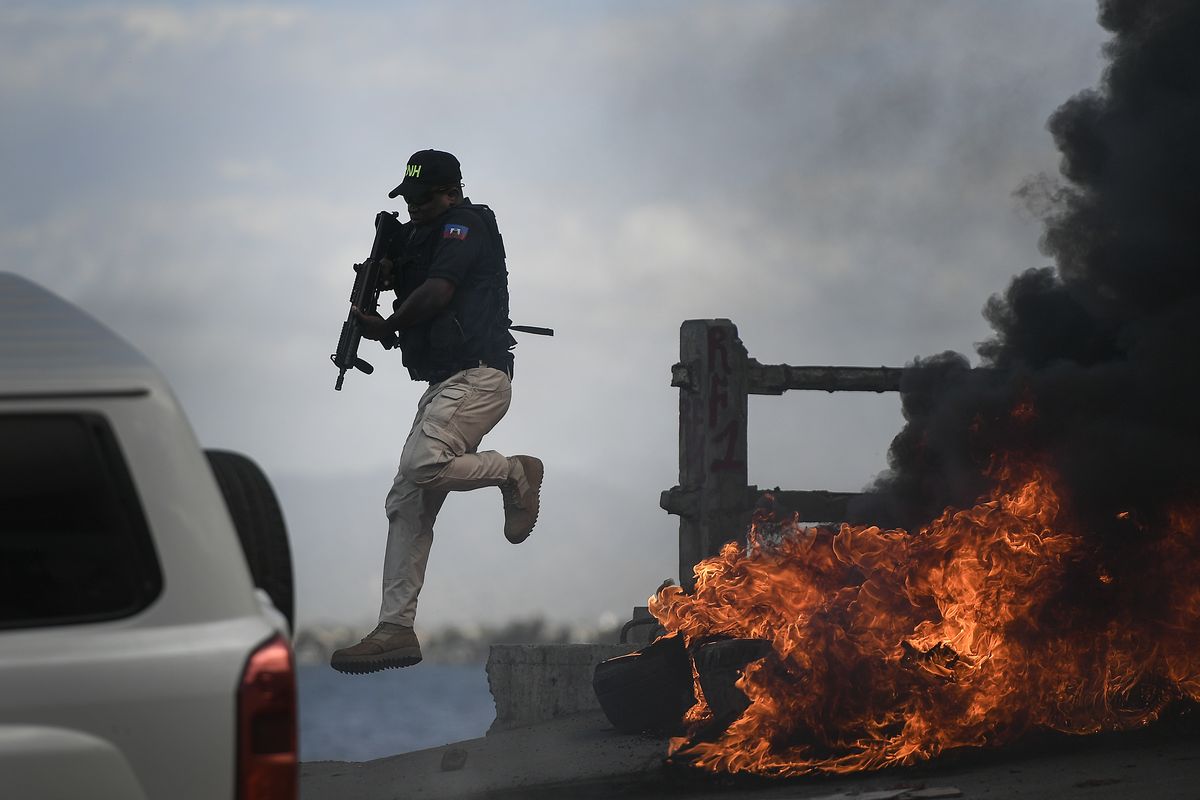 A police officer abandons his vehicle during a demonstration that turned violent in which protesters demanded justice for the assassinated President Jovenel Moise in Cap-Haitien, Haiti, Thursday, July 22, 2021. Demonstrations after a memorial service for Moise turned violent on Thursday afternoon with protesters shooting into the air, throwing rocks and overturning heavy concrete barricades next to the seashore as businesses closed and people took cover.  (Matias Delacroix)