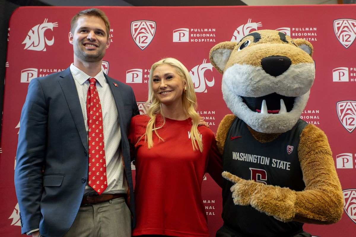 Washington State University head men's basketball coach David Riley and his wife, Emily Riley, pose with Butch the Cougar on Thursday, April 4, 2024, during a press conference at Gesa Field in Pullman.  (Geoff Crimmins/For The Spokesman-Review)