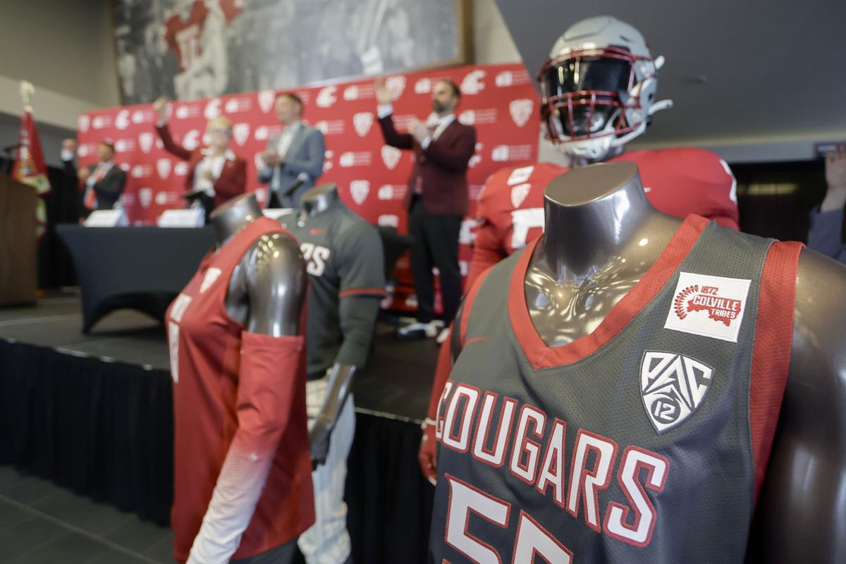 Washington State University President Betsy Cantwell, left, and athletic director Jon Haarlow, right, cheer to the university’s fight song with Jarred-Michael Erickson, chairman of the Confederated Tribes of the Colville Reservation, during a news conference Tuesday at Gesa Field in Pullman.  (Geoff Crimmins/For The Spokesman-Review)