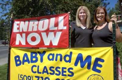 
Amee Johns, left, and Lisa Williams pose  near the opening sign for their new bilingual center at Audubon Park United Methodist Church in north Spokane. The preschool, called Happy Hands Sign Language center, will offer  instruction in both sign language and spoken English. 
 (KATE CLARK / The Spokesman-Review)