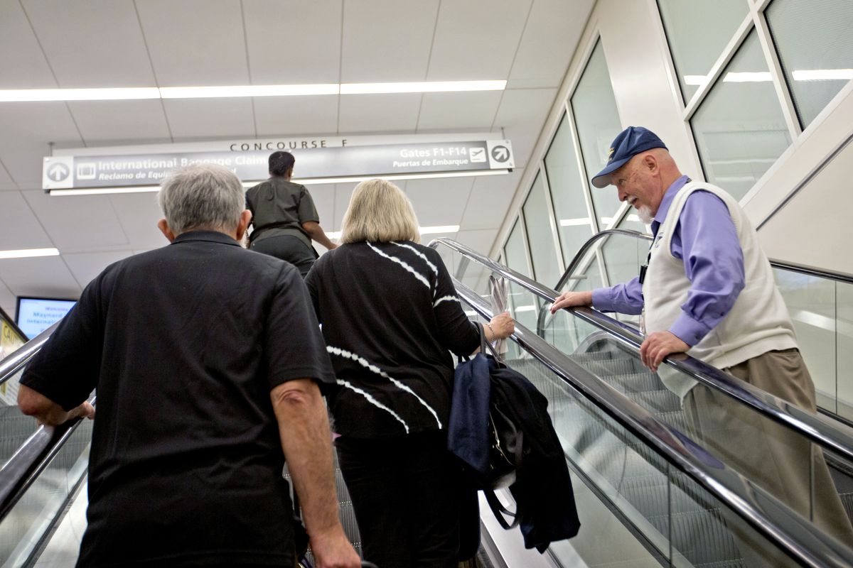 The Rev. Frank Colladay Jr. greets passengers on the escalator at Hartsfield-Jackson International Airport in Atlanta on Sept. 20. (Associated Press)