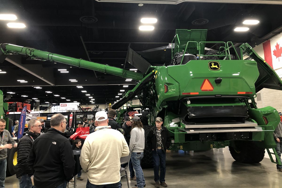 Onlookers gather near Pape Machinery’s massive John Deer X9 1100 combine on display Wednesday at the 2026 Spokane Ag Expo and Farm Forum.  (Thomas Clouse/The Spokesman-Review )