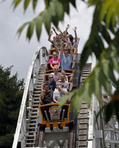 Riders go down one of the hills on the “Jack Rabbit” roller coaster at Kennywood Park in West Mifflin, Pa., last June. (Associated Press)