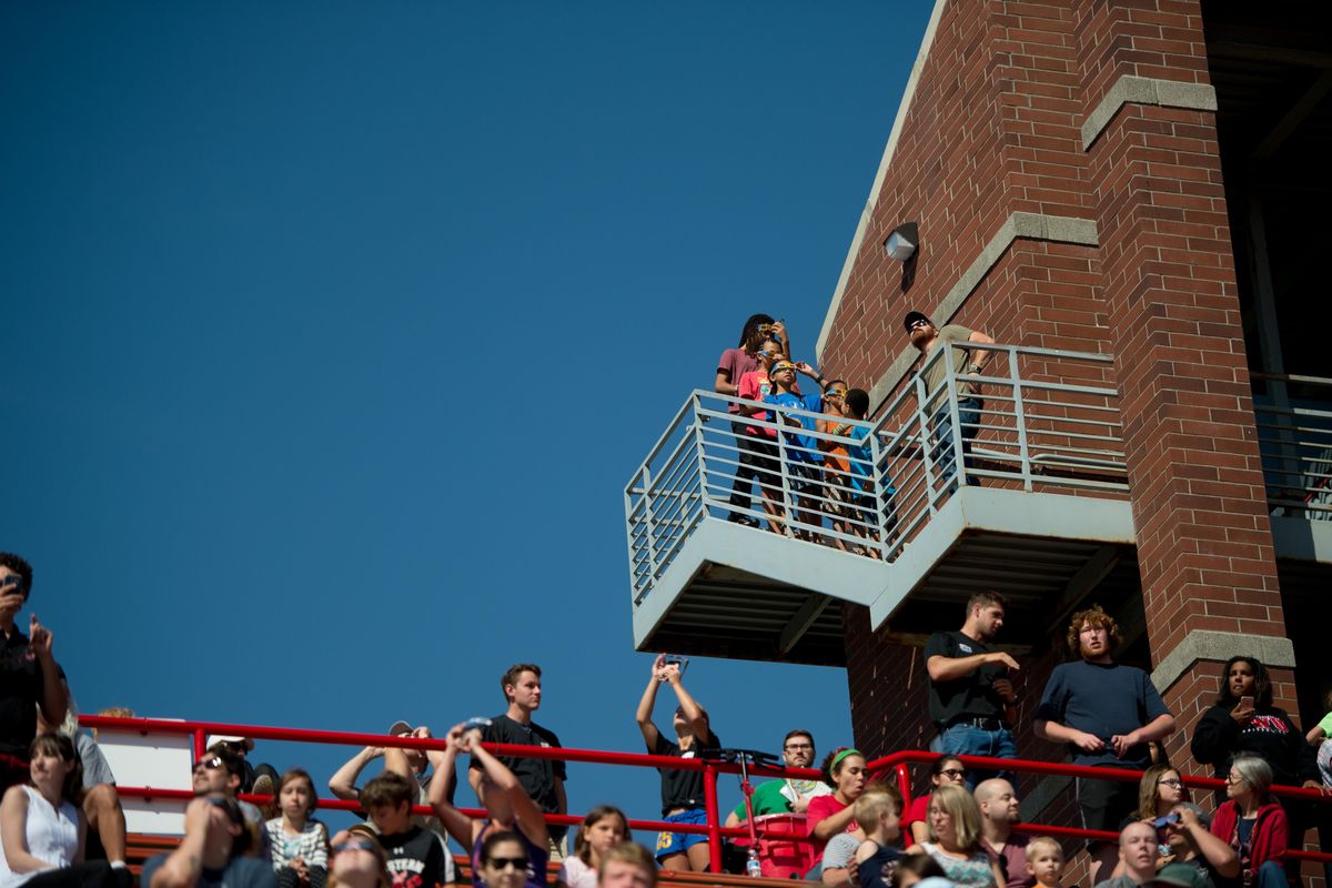 People take in a partial solar eclipse during a watch party held by the EWU Astronomy Club on Monday, Aug. 21, 2017, at Roos Field in Cheney, Wash. (Tyler Tjomsland / The Spokesman-Review)