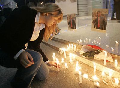 
A Lebanese woman lights a candle under pictures of slain anti-Syrian journalist and lawmaker Gibran Tueni during a vigil in front of the building of Tueni's An-Nahar newspaper in downtown Beirut, Lebanon, on Monday. 
 (Associated Press / The Spokesman-Review)