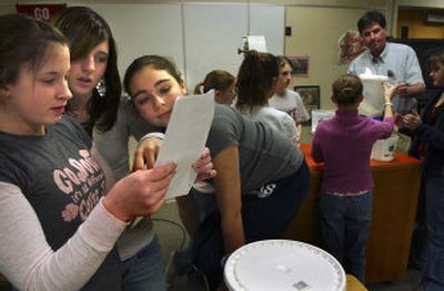 
From left, Stephanie Town, Lindsey Junkins and Katie Welch, seventh-graders at Centennial Middle School, learn to make root beer Wednesday during Biotech Club, an after-school program. They will come up with their own soda and a business plan to sell it online. 
 (Brian Plonka / The Spokesman-Review)