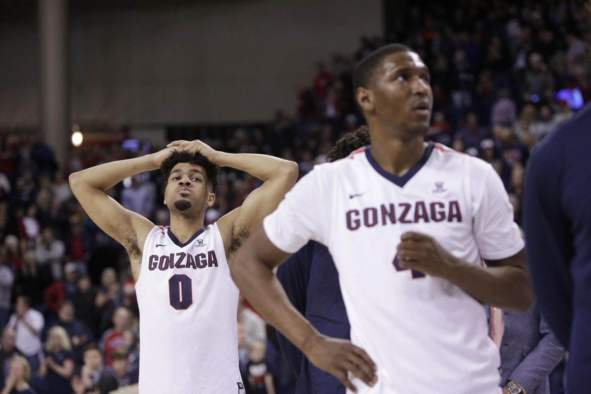 Gonzaga guards Silas Melson (left) and Jordan Mathews stand on the court during senior night speeches following Gonzaga’s loss to BYU on Saturday. (YOUNG KWAK / AP)