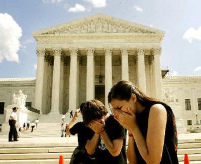 
Tanner Peake, 19, left, from Missoula, and Abigail Brown, 20, right, from Phoenix, Ariz., cover their faces as they pray together with other anti-abortion demonstrators on the steps of the Supreme Court on Monday.
 (Associated Press / The Spokesman-Review)