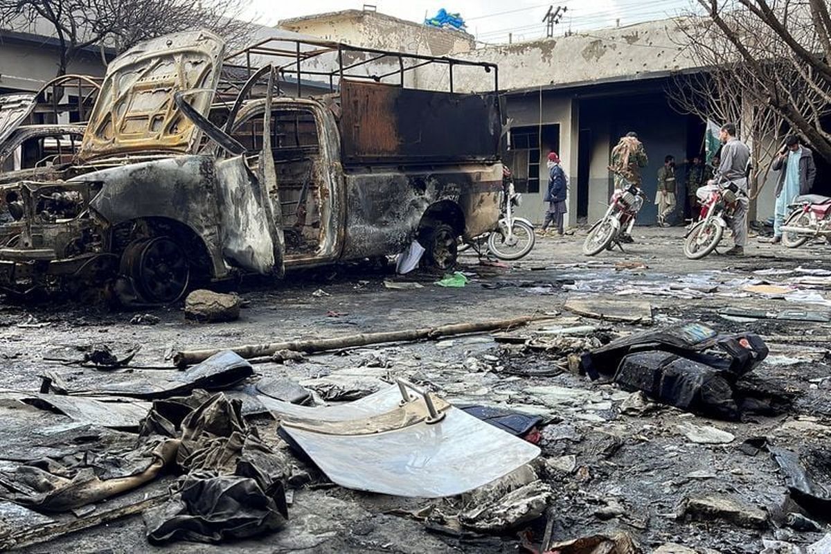 People walk amid damages at a police station following militant attacks on Sunday in Quetta, Pakistan.  (Reuters )