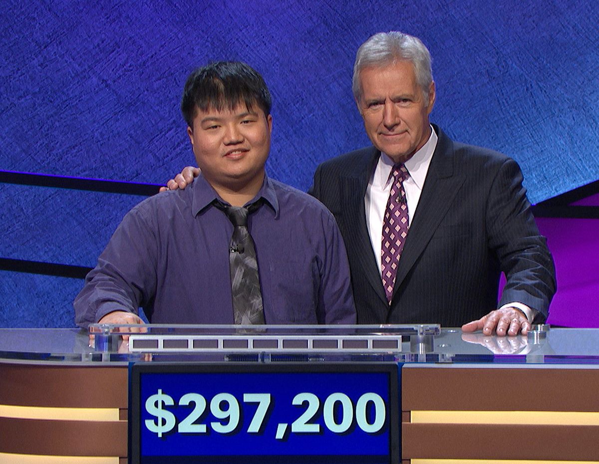 “Jeopardy!” host Alex Trebek poses with contestant Arthur Chu at a taping in Culver City, Calif. Chu reigned on the show for 12 days. (Associated Press)