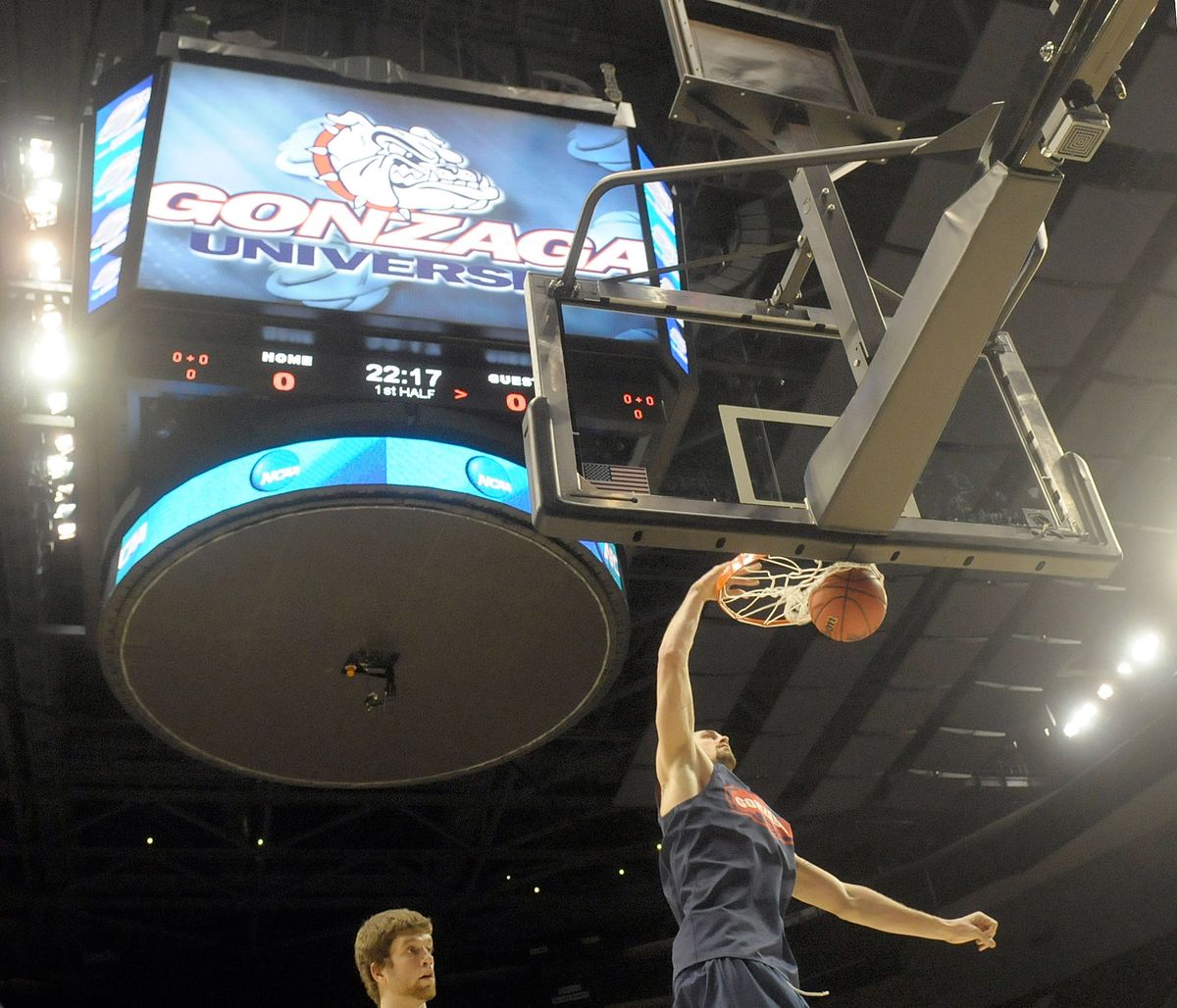 Will Foster ( bottom left ) watches as Josh Heytvelt dunks during practice in the Rose Garden. (Christopher Anderson / The Spokesman-Review)