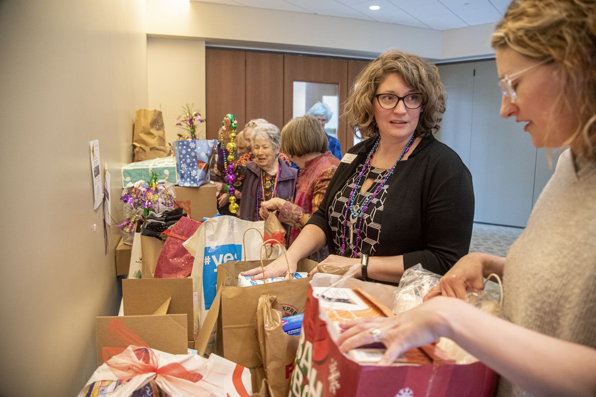 Transitions Executive Director Sarah Lickfold, second from right, and Rae-Lynn Barden, marketing and communications director for Volunteers of America, look over the bags of donations from residents at Rockwood Retirement South Hill on Monday at the end of the Mardi Bras fundraiser. The residents