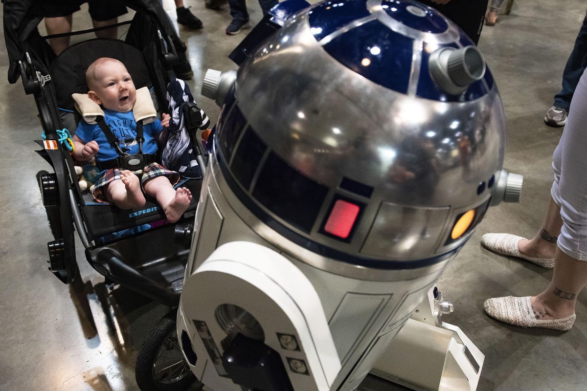 Jaxon King, 5 months, enjoys the sounds Star War droid R2-D2 makes on the exhibition floor of the Lilac City Comicon, Sunday, June 3, 2018, at the Spokane Convention Center. "He