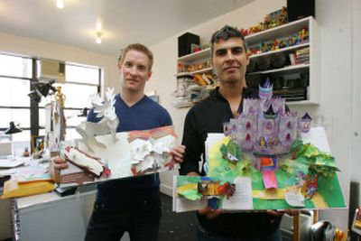 
Pop-up book makers Robert Sabuda, left, and Matthew Reinhart display two of their books at the studio they share in New York. Sabuda's book is a personal project titled 