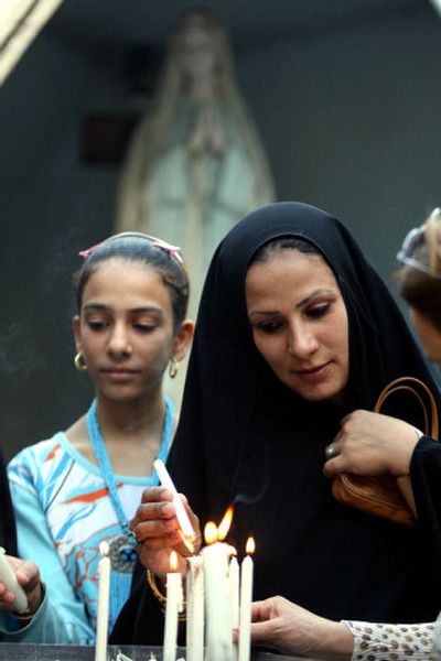 
A woman lights a candle after Sunday Mass in Baghdad. Iraq's biggest political parties on condemned comments by Pope Benedict XVI on Islam. 
 (Associated Press / The Spokesman-Review)