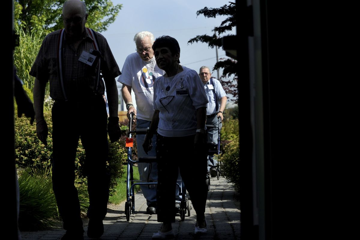 “This place is great,” said Frank Comer, center, as he goes for a morning walk along with other visitors at Providence Adult Day Health in Spokane. (Kathy Plonka)
