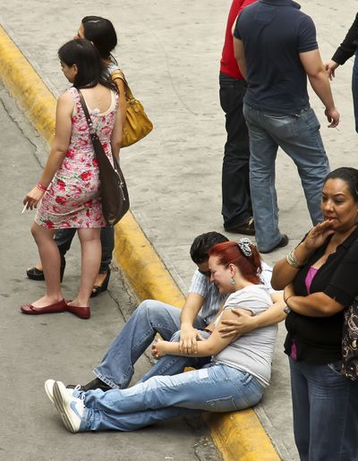 Victims’ relatives wait Friday at the site where Mexico’s government is testing DNA samples to match with fire victims in Monterrey. (Associated Press)