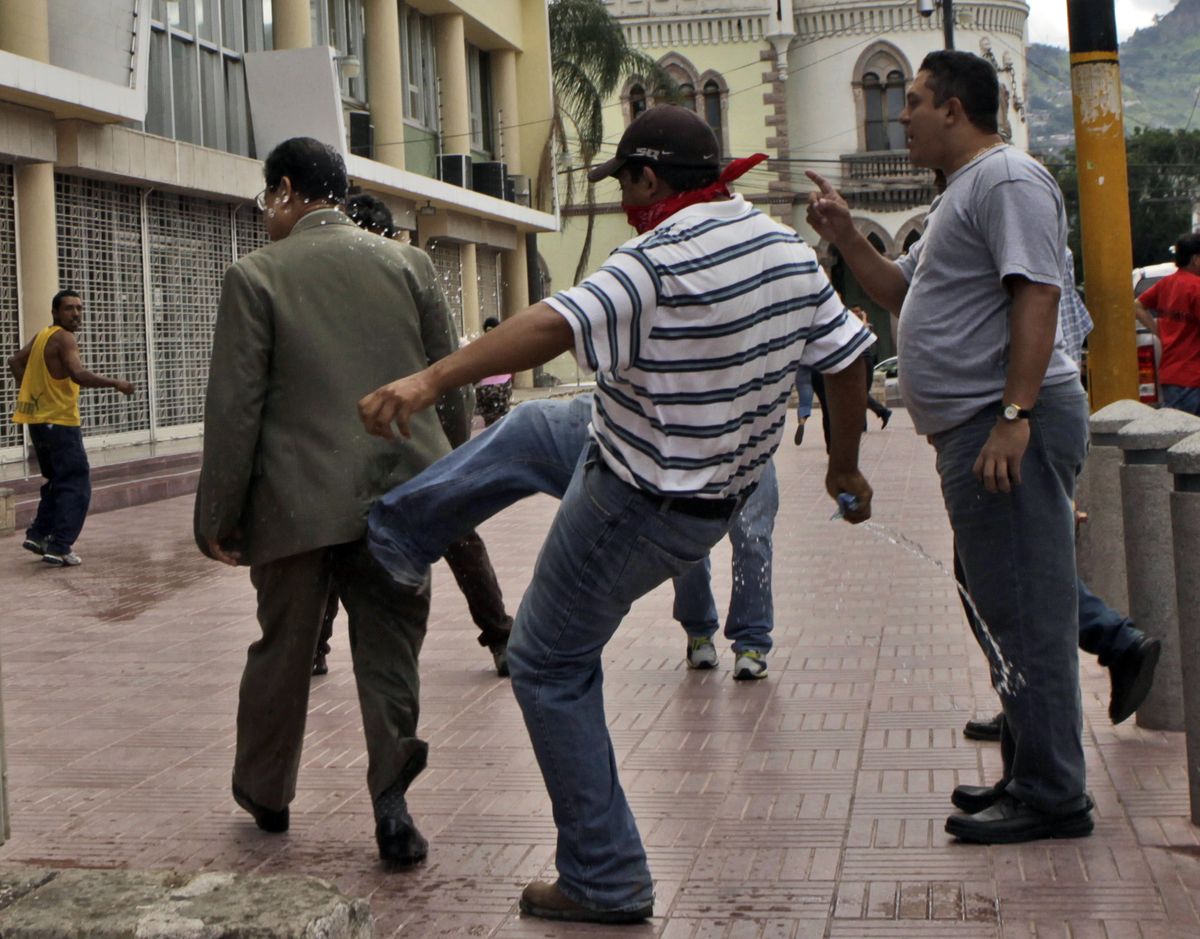 A supporter of Zelaya kicks Ramon Velasquez, vice president of the Honduran Congress, during protests. (Arnulfo Franco / The Spokesman-Review)