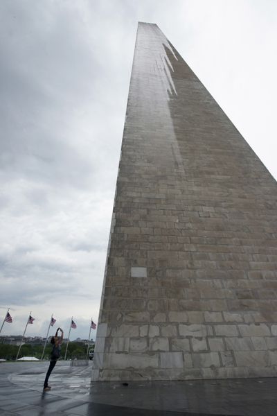 A journalist photographs the Washington Monument during a press preview Saturday prior to the reopening. (Associated Press)