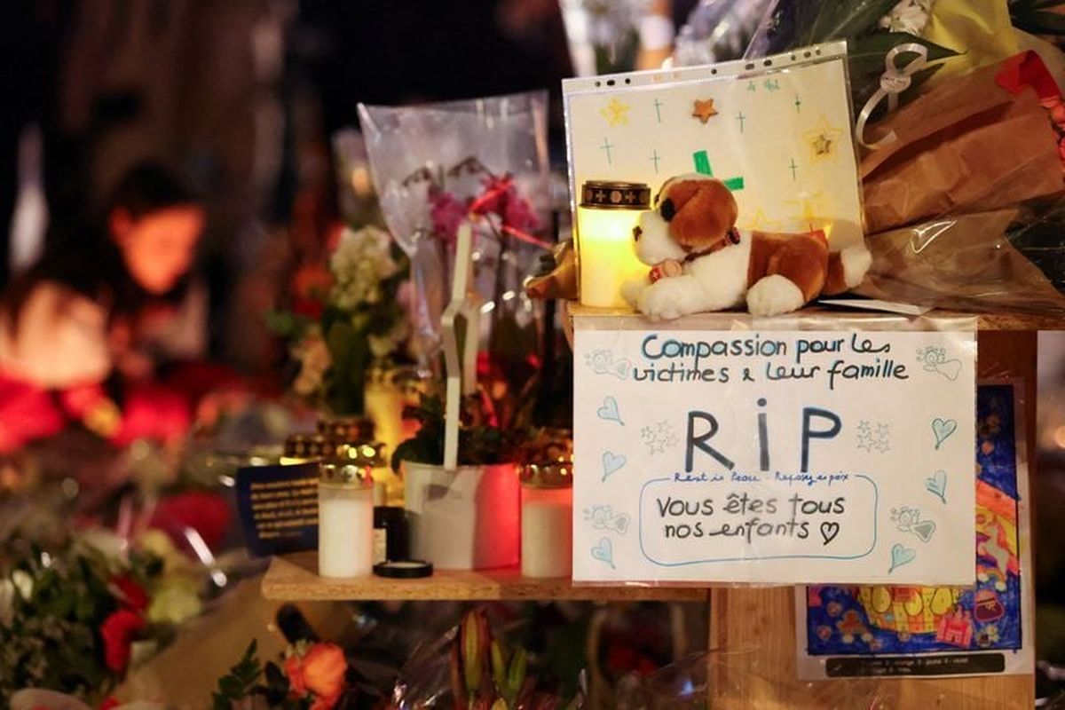 A sign reading "Compassion for the victims and their families, Rest in Peace, You are all our children" is placed at a makeshift memorial outside the "Le Constellation" bar, after a deadly fire and explosion during a New Year