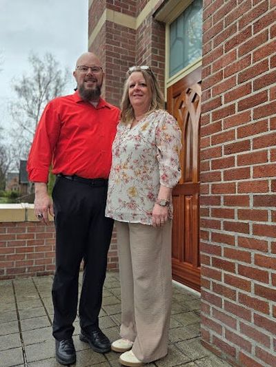 Colin Meyer, 58, and wife Kirstin, 53, on the front steps of their home church, St. Mary’s in Moscow, Idaho. They have been married for 35 years. “She is my lifeforce and my guiding light in my ministry, truly,” Meyer said.  (Lisa Ormond/FāVS News)