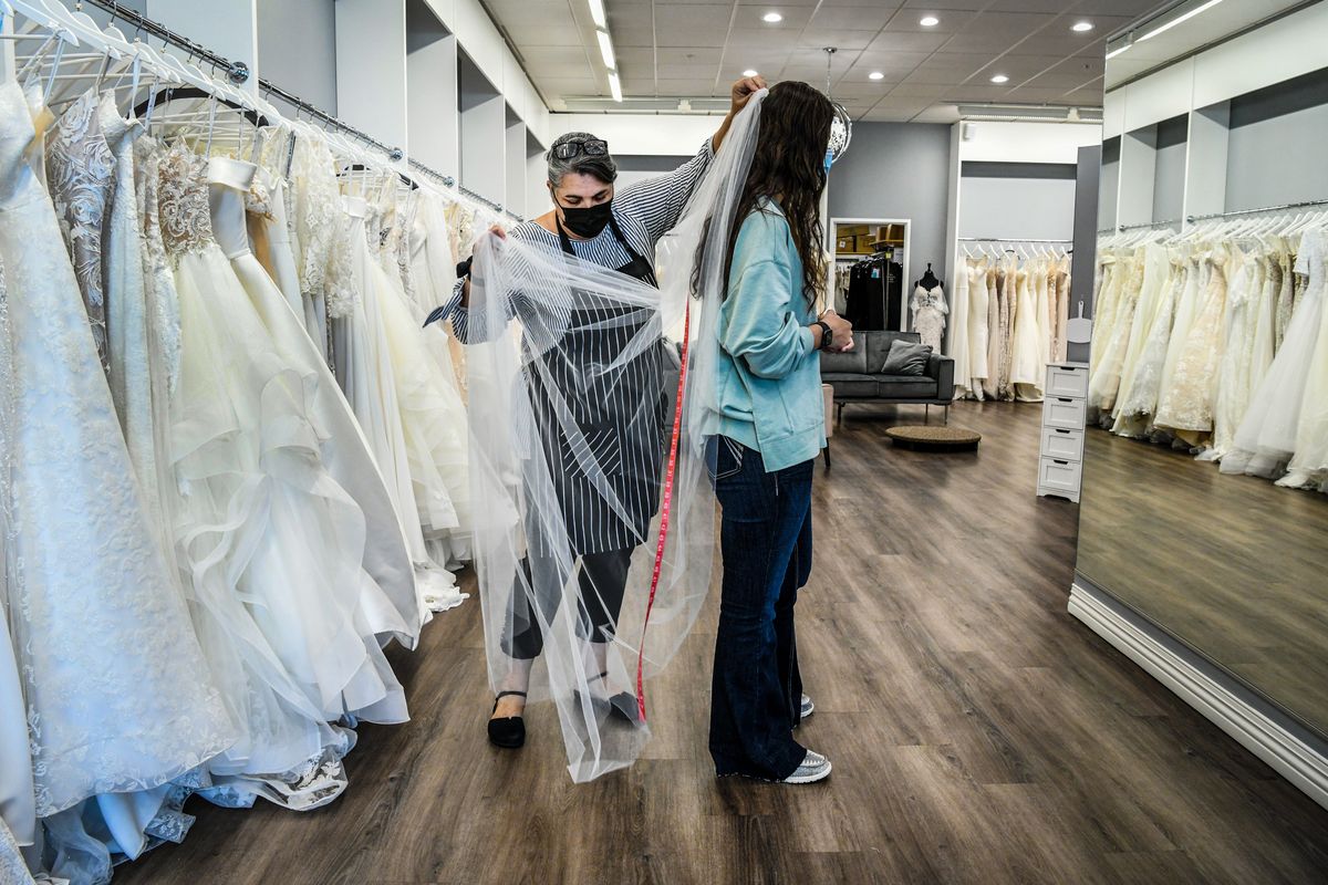 Marcella Davis, owner of Marcella’s Bridal, assists Jessica Guske with her final fitting and pickup, on Thursday in Spokane.  (DAN PELLE/THE SPOKESMAN-REVIEW)