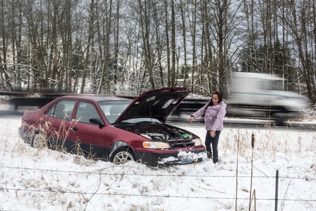 Sophin Long waits for a tow from a friend after losing control in snow on I-5 before the 300th St. NW exit north of Arlington on Wednesday, Jan. 15, 2020 in Seattle. (Steve Ringman / Associated Press)