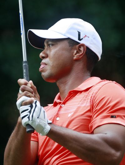 Tiger Woods watches his tee shot on the fourth hole.  (Associated Press / The Spokesman-Review)