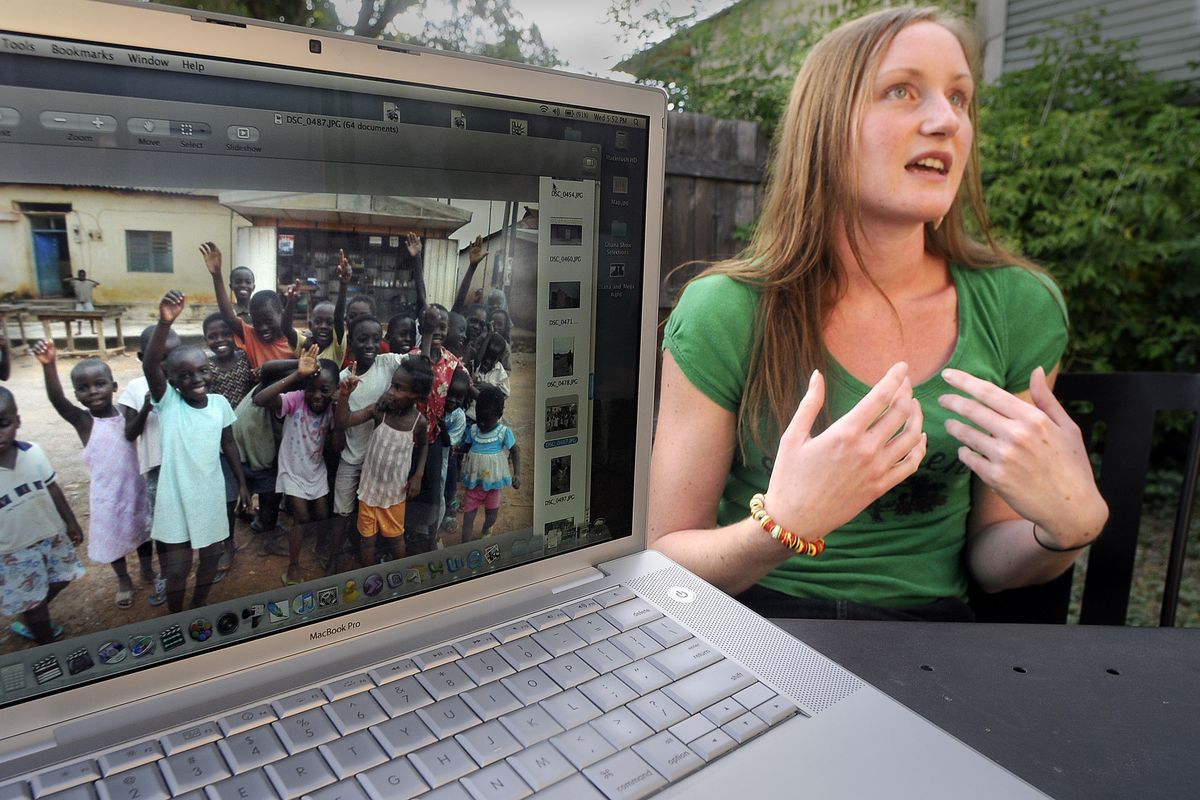 Megan Schuyler, photographed in her Spokane backyard recently, shows photos  of her trip  to Ghana and talks about “One Single Bucket,” the documentary she helped create. (CHRISTOPHER ANDERSON / The Spokesman-Review)