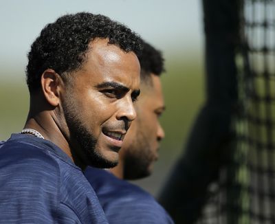 Nelson Cruz, left, and Robinson Cano watch a drill during spring training baseball practice on Tuesday. (Charlie Riedel / Associated Press)