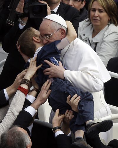 Pope Francis hugs a child after celebrating his first Easter Mass in St. Peter’s Square at the Vatican on Sunday. (Associated Press)