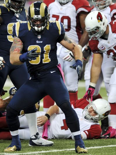 Rams defensive end Chris Long, left, celebrates after sacking Cardinals quarterback Kevin Kolb. (Associated Press)