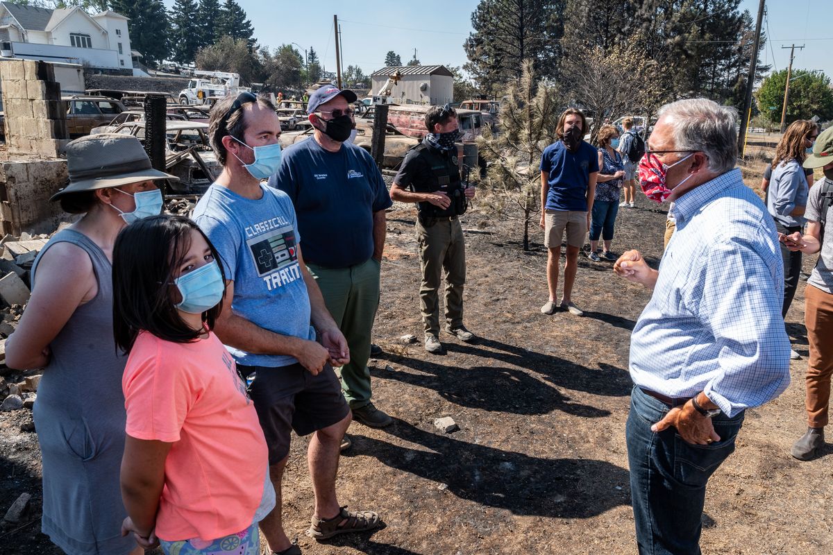 Gov. Jay Inslee, on far right, speaks with, right to left, Matthew Graham, his wife Jessica and daughter Claudia in the fire-devastated town of Malden. The Grahams lost their home in the 2020 wildfire.  (Colin Mulvany/THE SPOKESMAN-REVIEW)