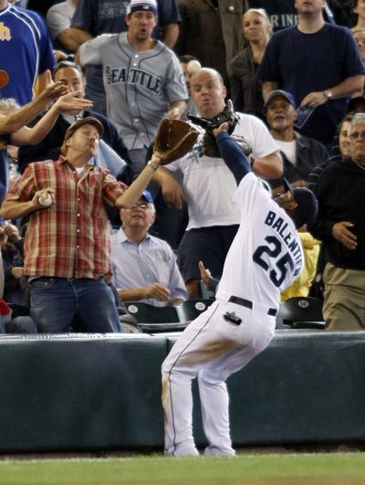 Mariners left fielder Wladimir Balentien reaches into the stands to catch a fly ball in the seventh inning. (Associated Press / The Spokesman-Review)