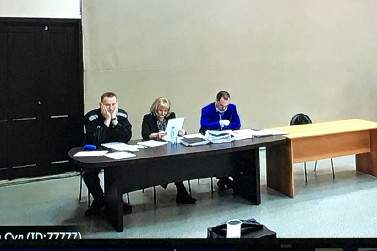 In this image provided by the Russian Federal Penitentiary Service, Russian opposition leader Alexei Navalny, left, is seen via a video link, sitting next to his layers during a court session in Pokrov, Vladimir region, about 100 kilometers (62 miles) east of Moscow, Russia, Tuesday, March 15, 2022. The Russian authorities are seeking a 13-year prison sentence for opposition leader Alexei Navalny in a trial that is widely seen as politically motivated.  (HOGP)