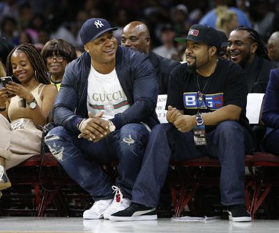 In this July 16, 2017 photo, LL Cool J, second from front left, and Ice Cube watch the action as The Power plays the Ghost Ballers during the first half of a BIG3 basketball game in Philadelphia, Pa. Whether sitting courtside in Philly or filming in Hollywood, Ice Cube remains the famous face of his 3-on-3 halfcourt Big3 basketball league. (Rich Schultz / Associated Press)