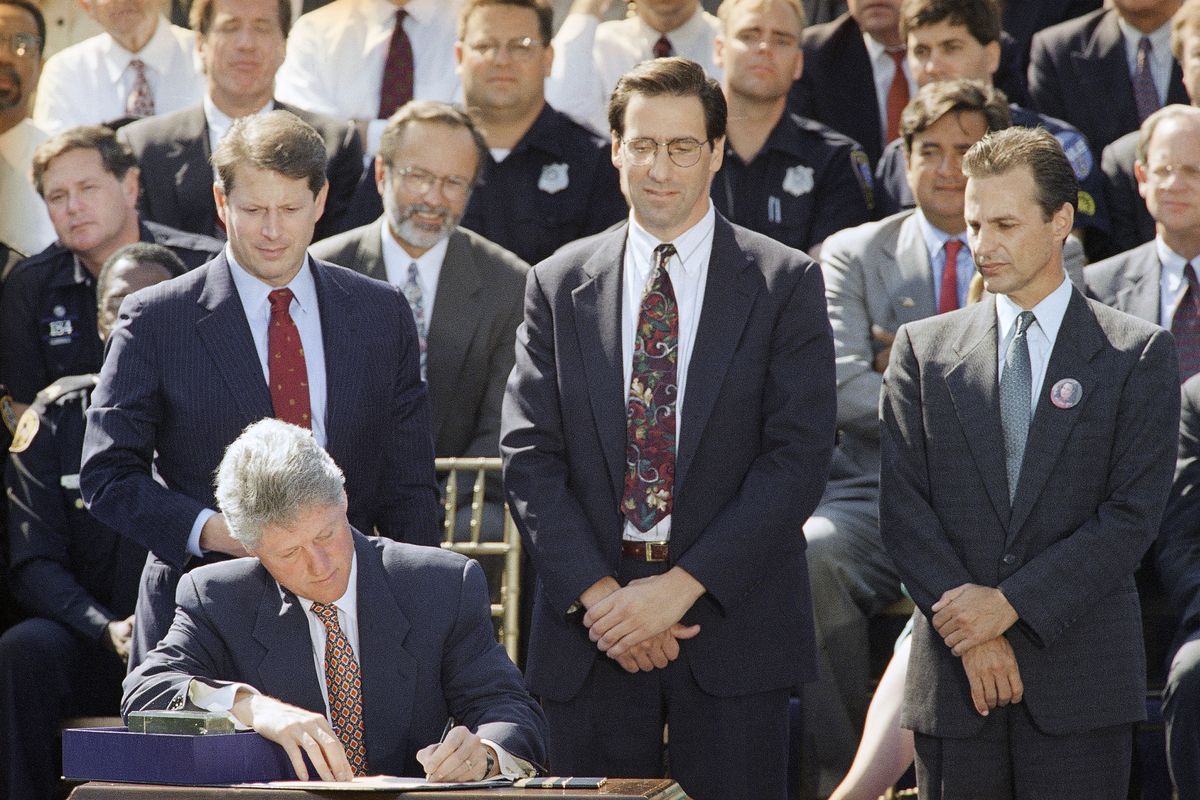 President Bill Clinton signs the $30 billion crime bill during a ceremony Sept. 13, 1994, on the South Lawn of the White House in Washington. (Associated Press)